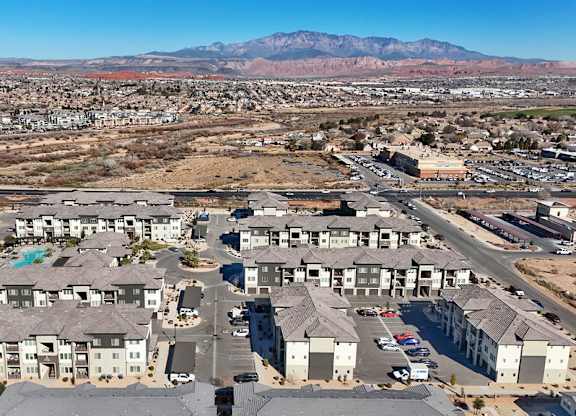 A large, modern apartment complex sits in the middle of a desert-like landscape.