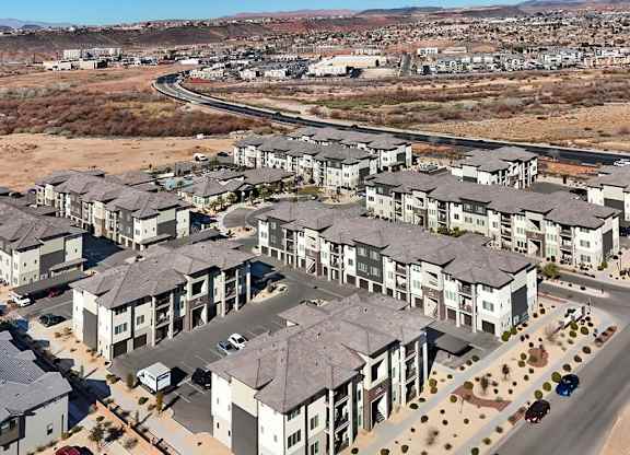 A large housing development with multiple buildings and cars parked in the driveways.
