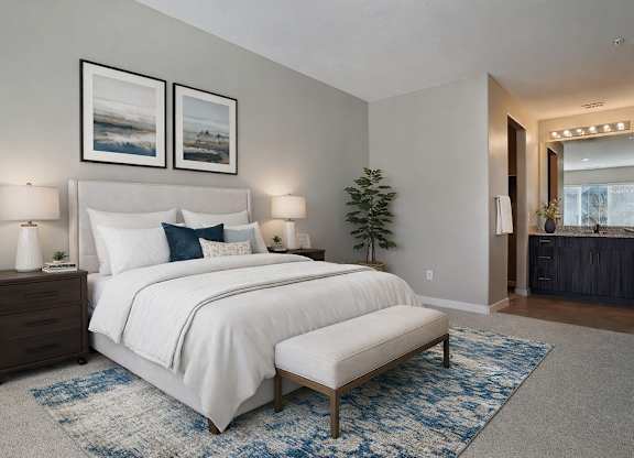 A bedroom with a large bed and two lamps.