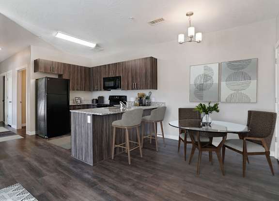 A kitchen with a black fridge and a white counter top.