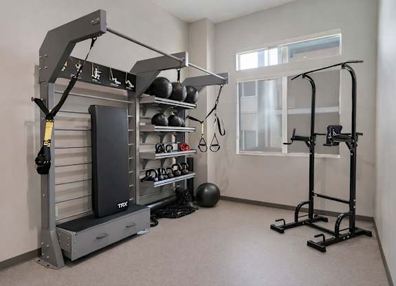 A home gym with a squat rack, bench, and weights.