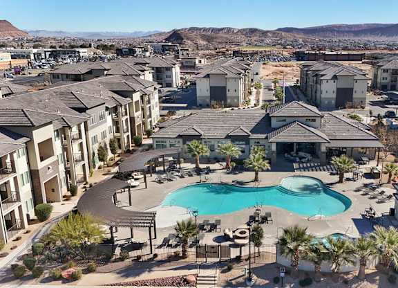 A large swimming pool is surrounded by apartment buildings.