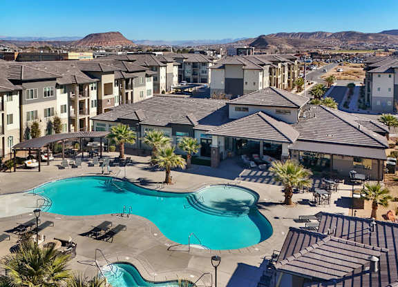 A large swimming pool is surrounded by apartment buildings.