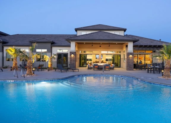 an evening view of a resort style swimming pool in front of the clubhouse at Brookfield Apartments in St. George, Utah.