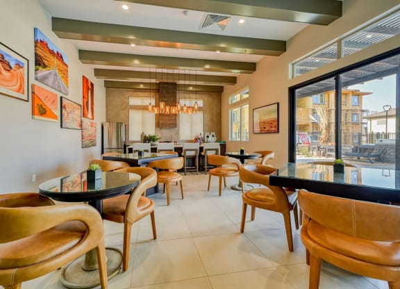 a dining area with tables and chairs and a large window at Brookfield Apartments for rent in St. George