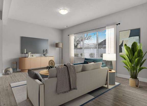 A living room with a couch, a mirror, a lamp, and a potted plant.