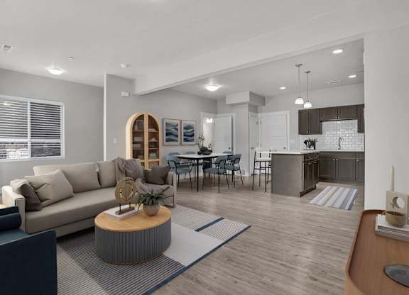 A modern living room with a grey sofa, a wooden coffee table, and a dining area in the background.