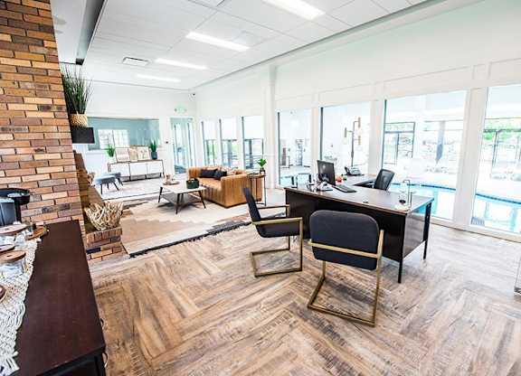 A modern office space with a brick wall and wooden flooring.
