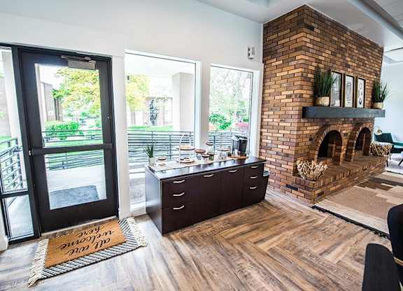 A modern interior with a brick fireplace and a kitchen island.