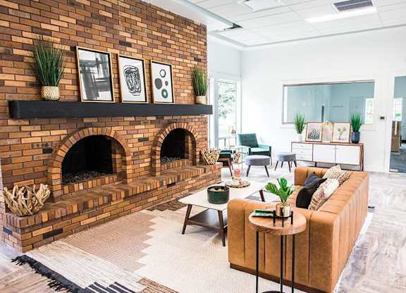 A living room with a brick fireplace and a couch.