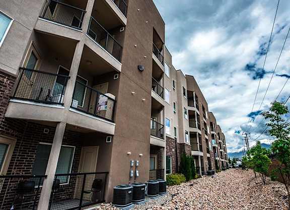 A row of apartment buildings with balconies and black railings.