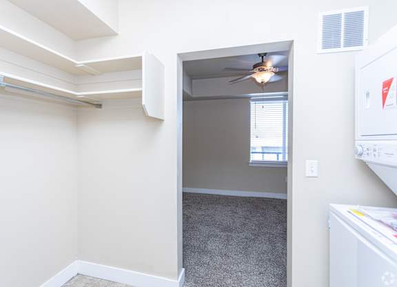A room with a ceiling fan and a window.