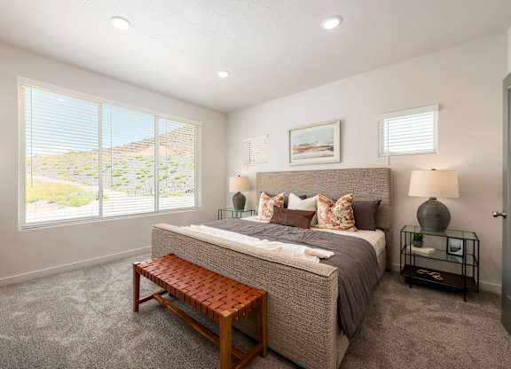 A bedroom with a large bed and a bench in front of it.