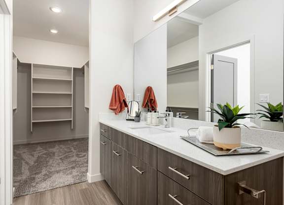 A bathroom with a sink, mirror, and towel rack.