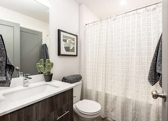 A bathroom with a toilet, sink, and shower curtain.