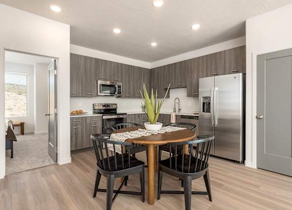A modern kitchen with a dining table set for four.