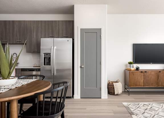 A modern kitchen with a wooden table and chairs.
