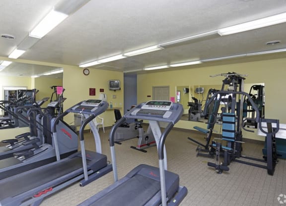 a gym with various machines and weights in a building