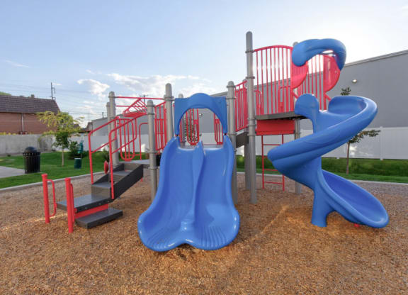 a playground with a blue slide and a red
