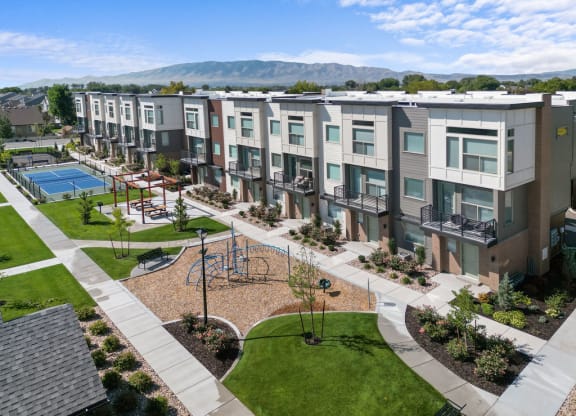 an aerial view of an apartment complex with a tennis court and a pool