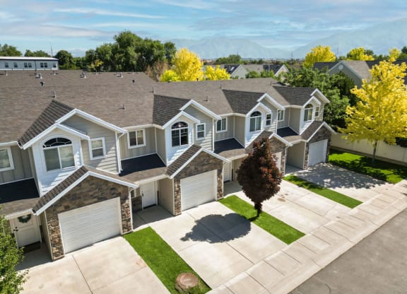 an aerial view of a house with a driveway and garage doors