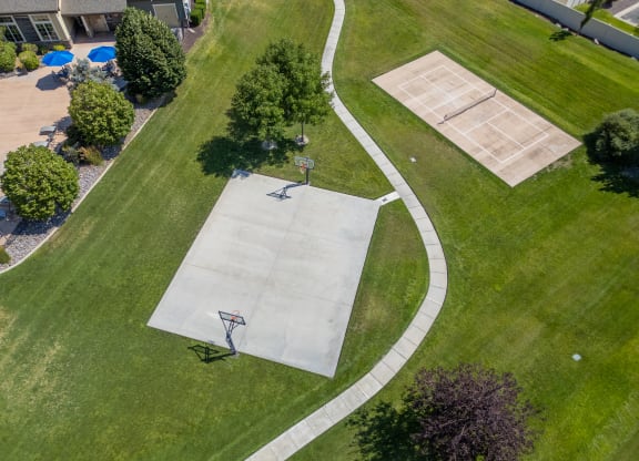 two people playing basketball on a court in a park at Aldara Apartments in Saratoga Springs, Utah