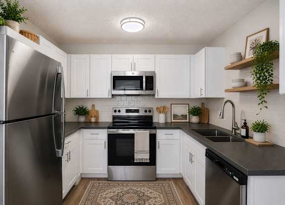 A kitchen with white cabinets and a black countertop.
