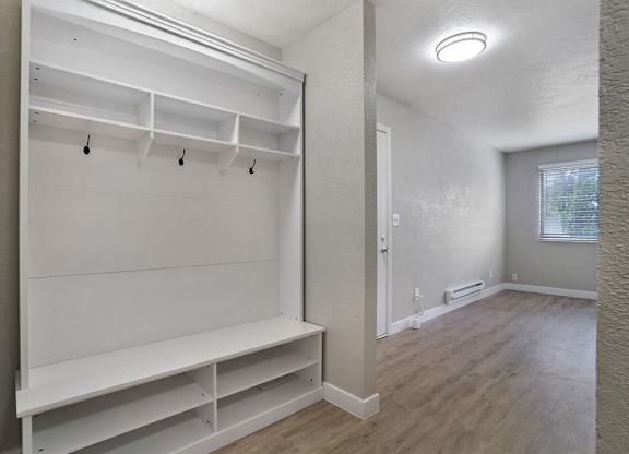 A white closet with shelves and a bench.