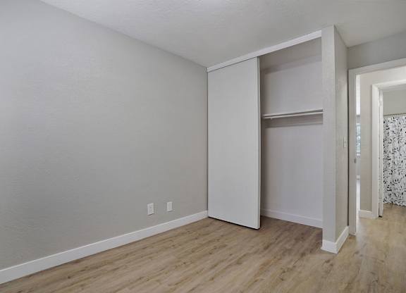 A room with a white wall and a white closet.