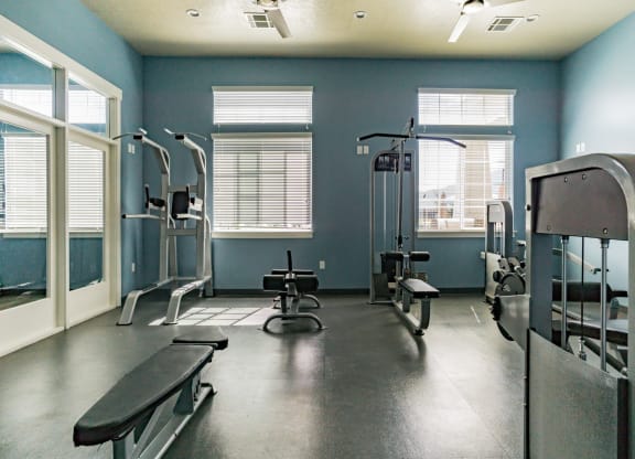 a gym with weights and cable workout equipment at Outlook Apartments in Springville and Provo, Utah