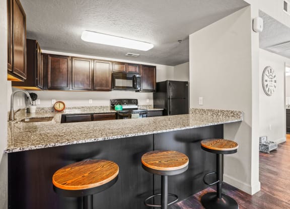 a kitchen with a counter top and a bar with stools