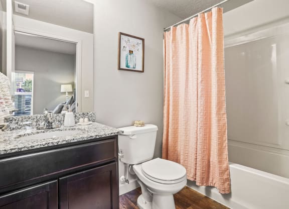 a bathroom with a toilet and a shower and a sink