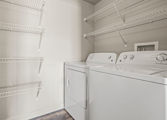 a laundry room with a washer and dryer and a closet with shelves