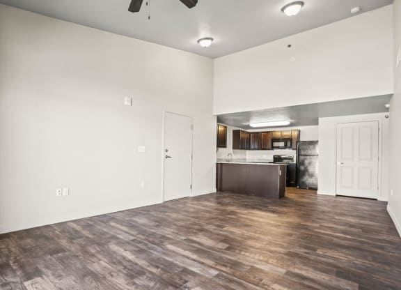 the living room and kitchen of a new home with white walls and wood flooring