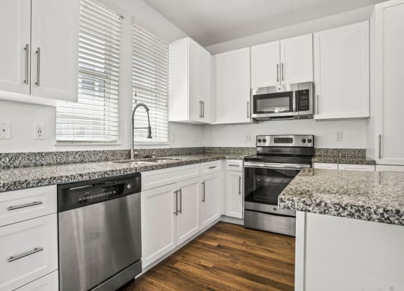 a kitchen with granite counter tops and stainless steel appliances at Aero Luxury Townhomes in Layton, Utah