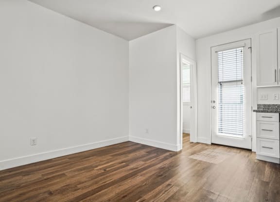 a living room with white walls and wood floors  at Aero Luxury Townhomes in Layton, Utah