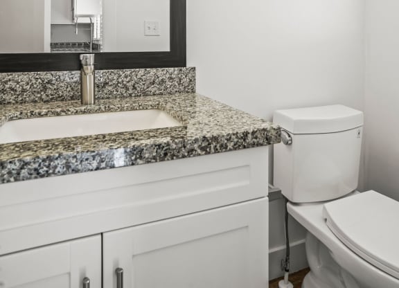 a bathroom with a sink and a toilet and a mirror  at Aero Luxury Townhomes in Layton, Utah