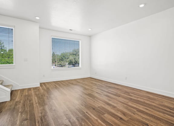 an empty living room with wood floors and a window  at Aero Luxury Townhomes in Layton, Utah