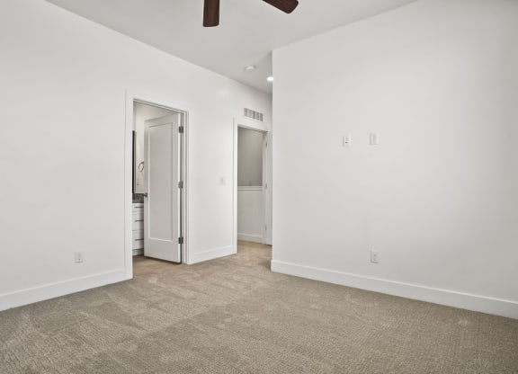 a living room with white walls and a door to a bathroom  at Aero Luxury Townhomes in Layton, Utah