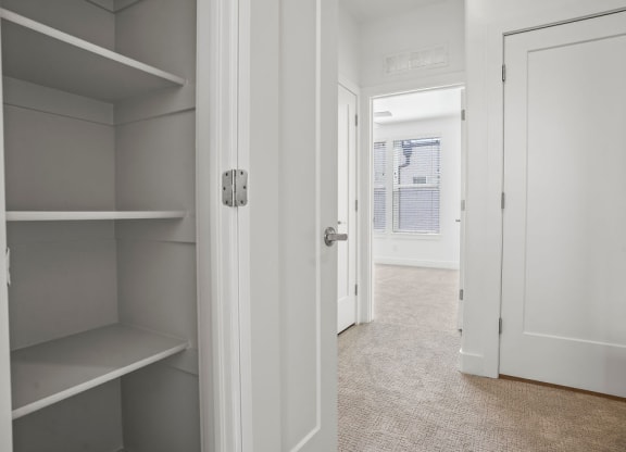 a walk in closet with shelves and a door to a bedroom  at Aero Luxury Townhomes in Layton, Utah