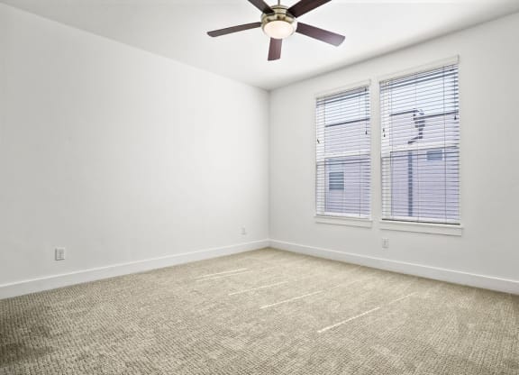 an empty room with a ceiling fan and a window  at Aero Luxury Townhomes in Layton, Utah
