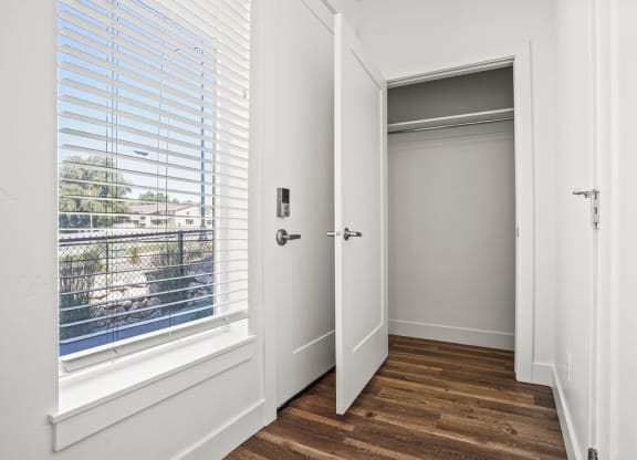 a bedroom with a window and a door to a closet  at Aero Luxury Townhomes in Layton, Utah