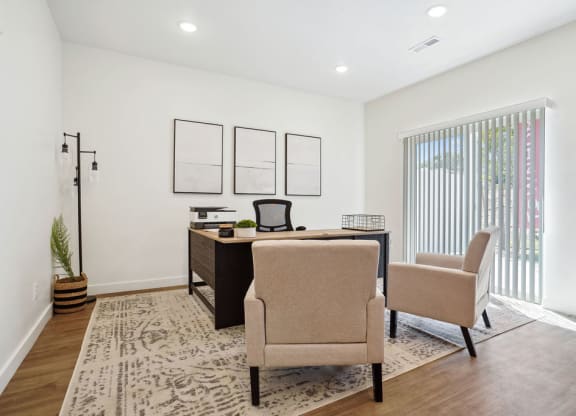 an office with two chairs and a desk and a window