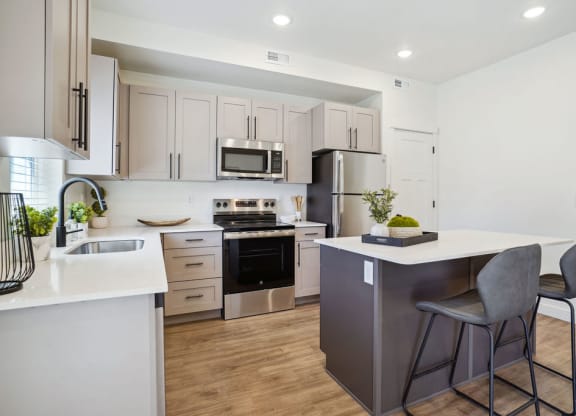 an open kitchen with an island with two stools