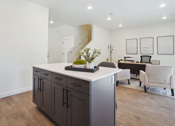 a kitchen with an island and a living room with a desk