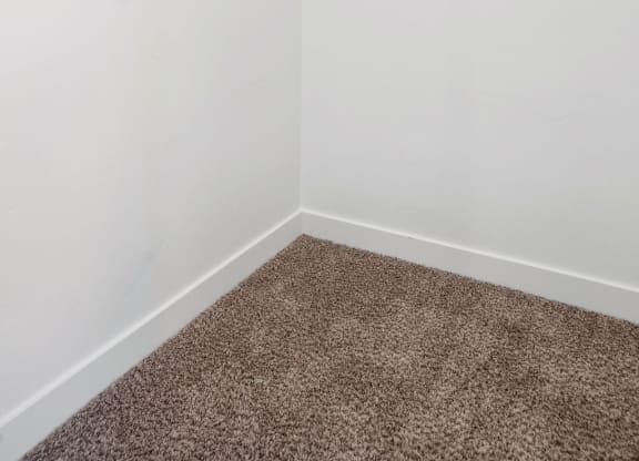an empty room with white walls and a carpet