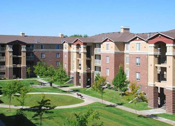 A large apartment complex with a grassy courtyard in the middle.