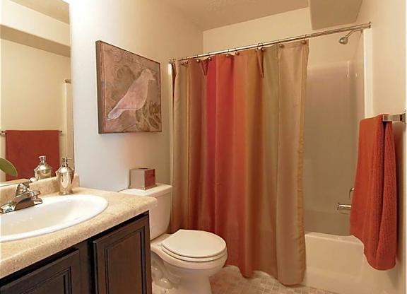 A bathroom with a toilet, sink, and shower.