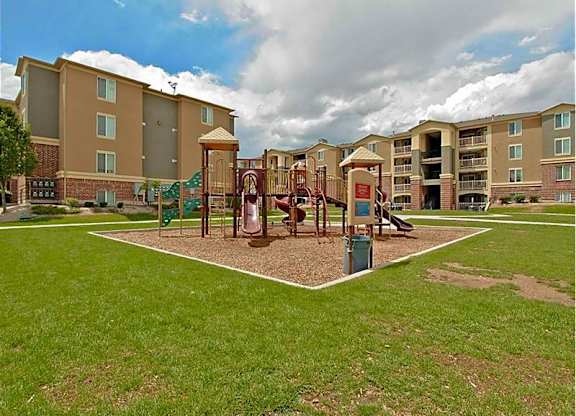A playground area in front of apartment buildings.