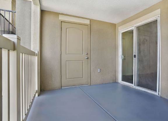 A balcony with a door and a window.